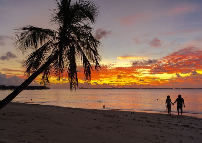 Honeymoon all-inclusive - walking on the beach at sunset