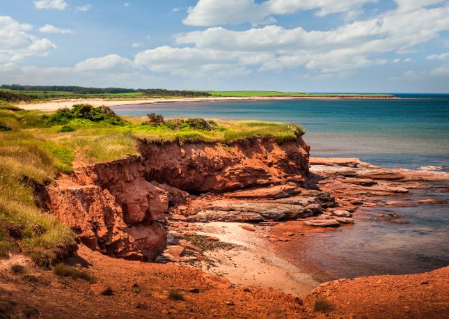 Visit Prince Edward Islands rolling green landscapes and red sand beaches.