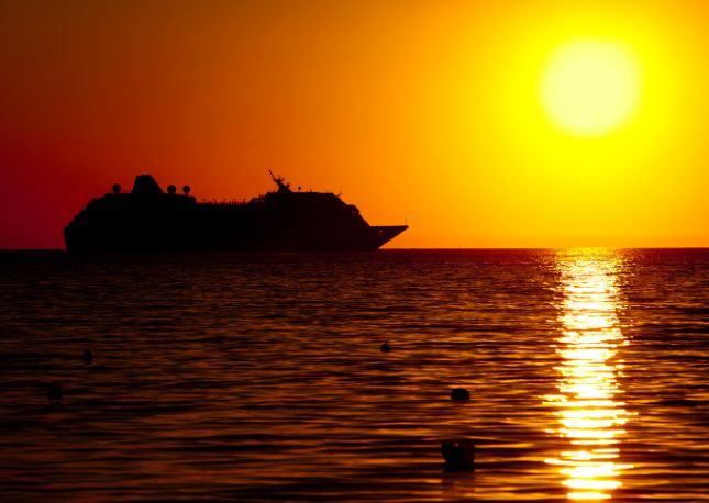 Cruise ship sailing at sunset
