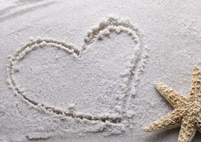 A heart in the sand with a starfish